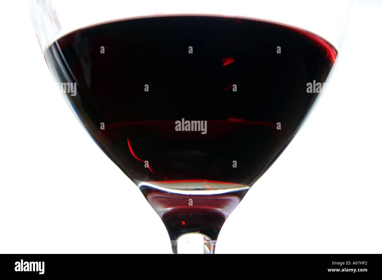 close up of glass of red wine against white background from below Stock