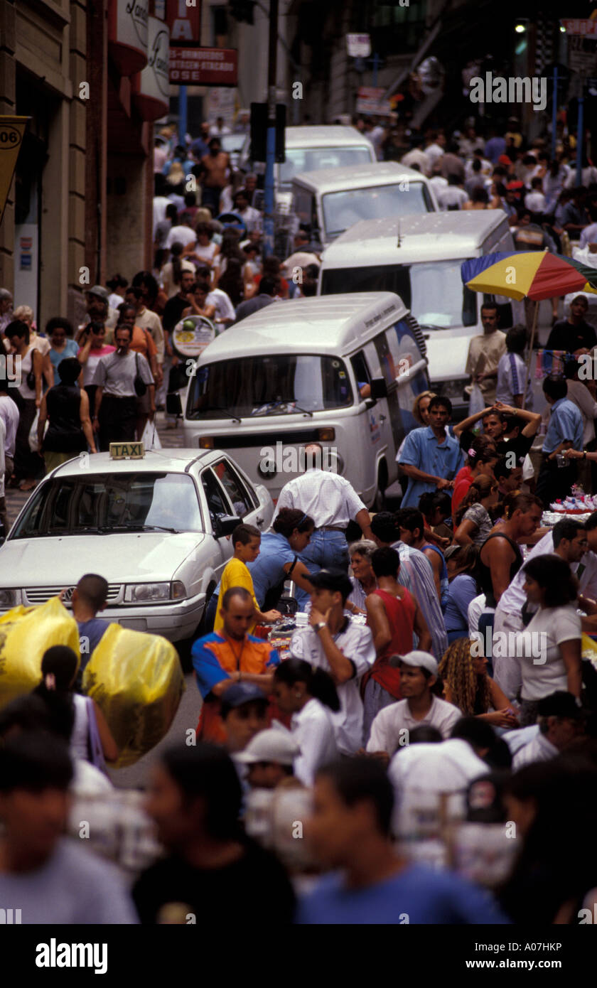 Street vendors, pedestrians and cars dispute a place in the narrow streets of downtown Sao Paulo, Brazil. Stock Photo