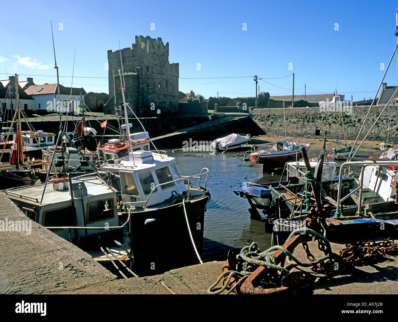 SLADE Co Wexford Republic of Ireland Europe October Slade Castle ruins overlooking the harbour with traditional fishing boats Stock Photo