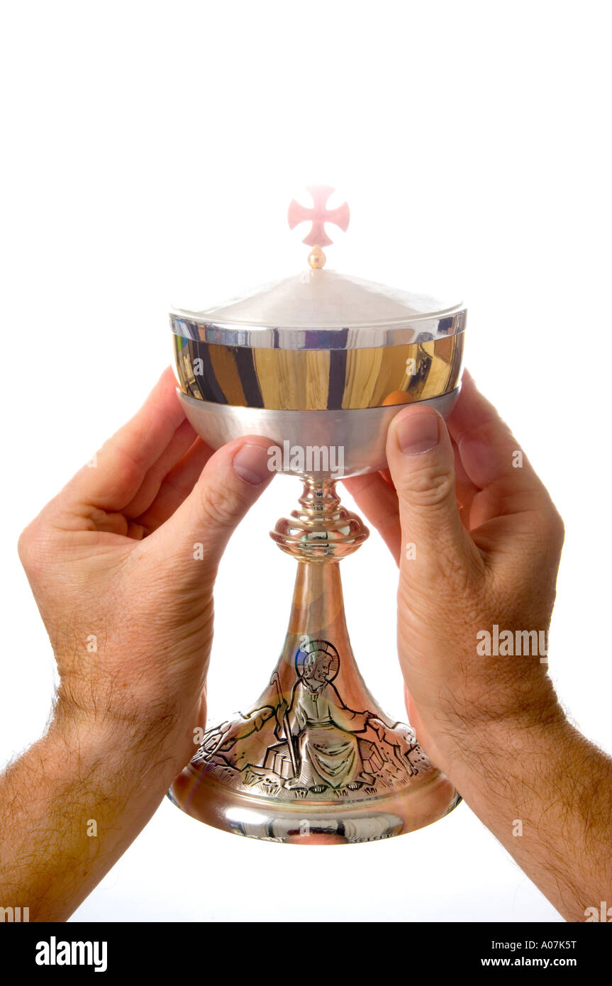 A priest's hands holding a communion cup of the Roman Catholic church - a ciborium Stock Photo