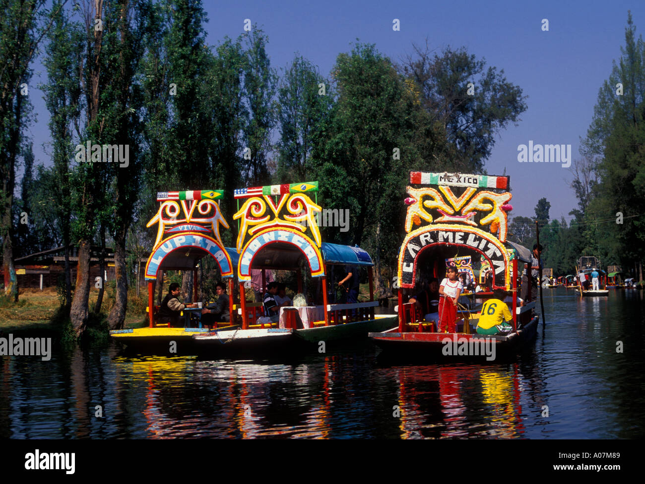 Brightly colored, trajineras, flat-bottom barges, along, canal, Floating Gardens, Xochimilco, Mexico City, Mexico Stock Photo