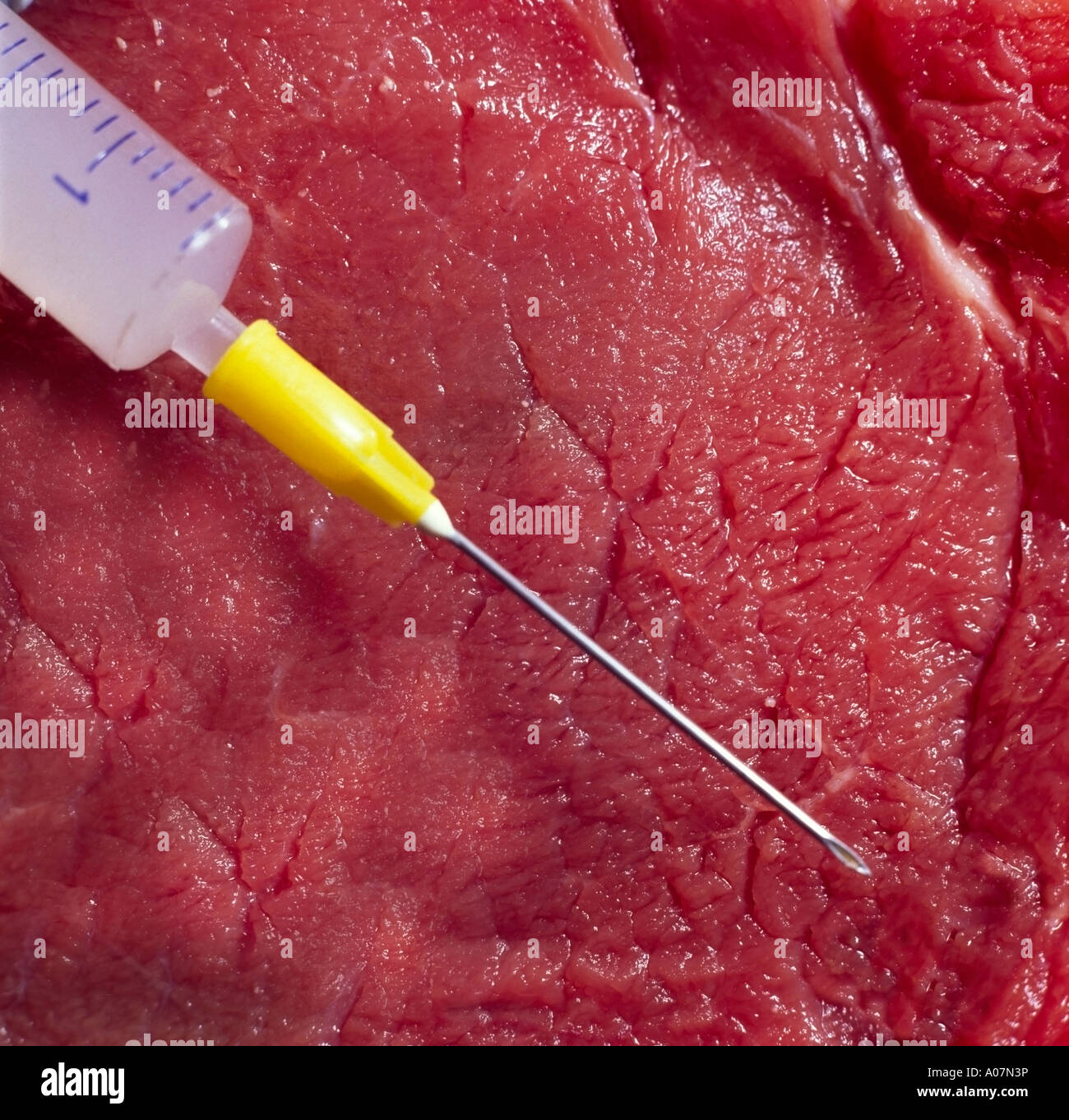 close up of meat beef with a syringe jab shot in front of the piece of meat Stock Photo