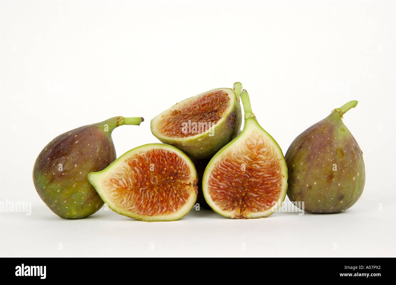 Fresh figs are sliced open, displaying their rich, colorful flesh and ...