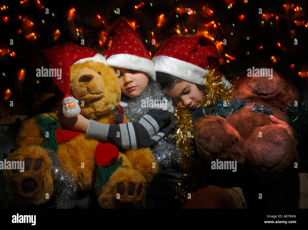 Children sleeping with Christmas teddy bears Stock Photo