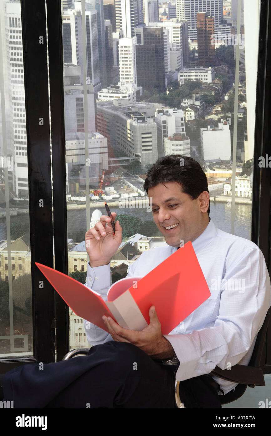 CEO reading business report in his cabin with city background Stock