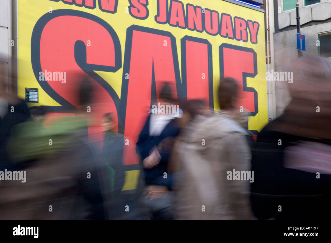 Bargain hunters shoppers walk past Sale signage in Oxford Street at beginning of January Sales Stock Photo