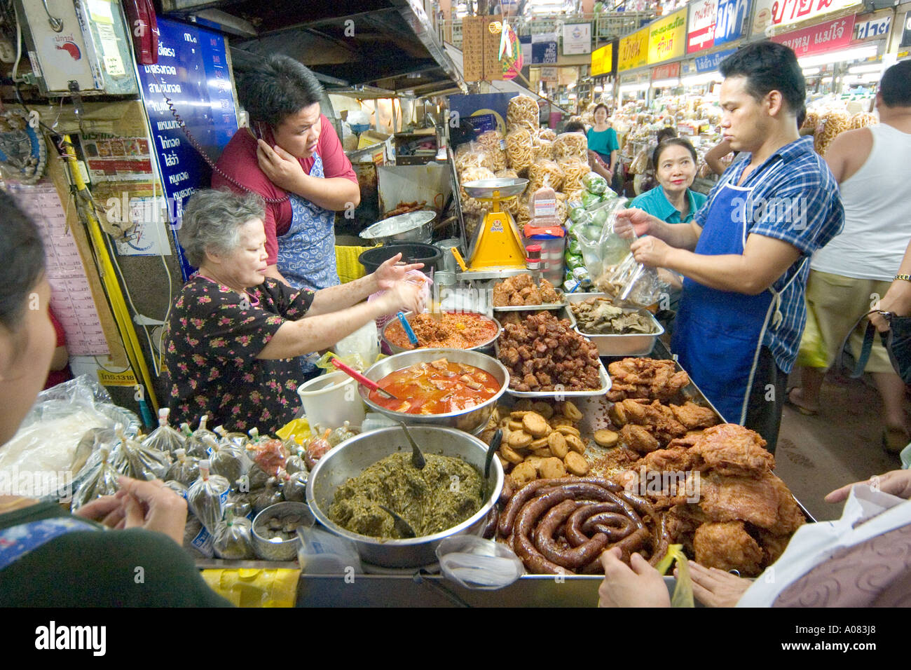 Market stall selling cooked meats sausage fish and fried foods in Chaing Mai Thailand Stock Photo