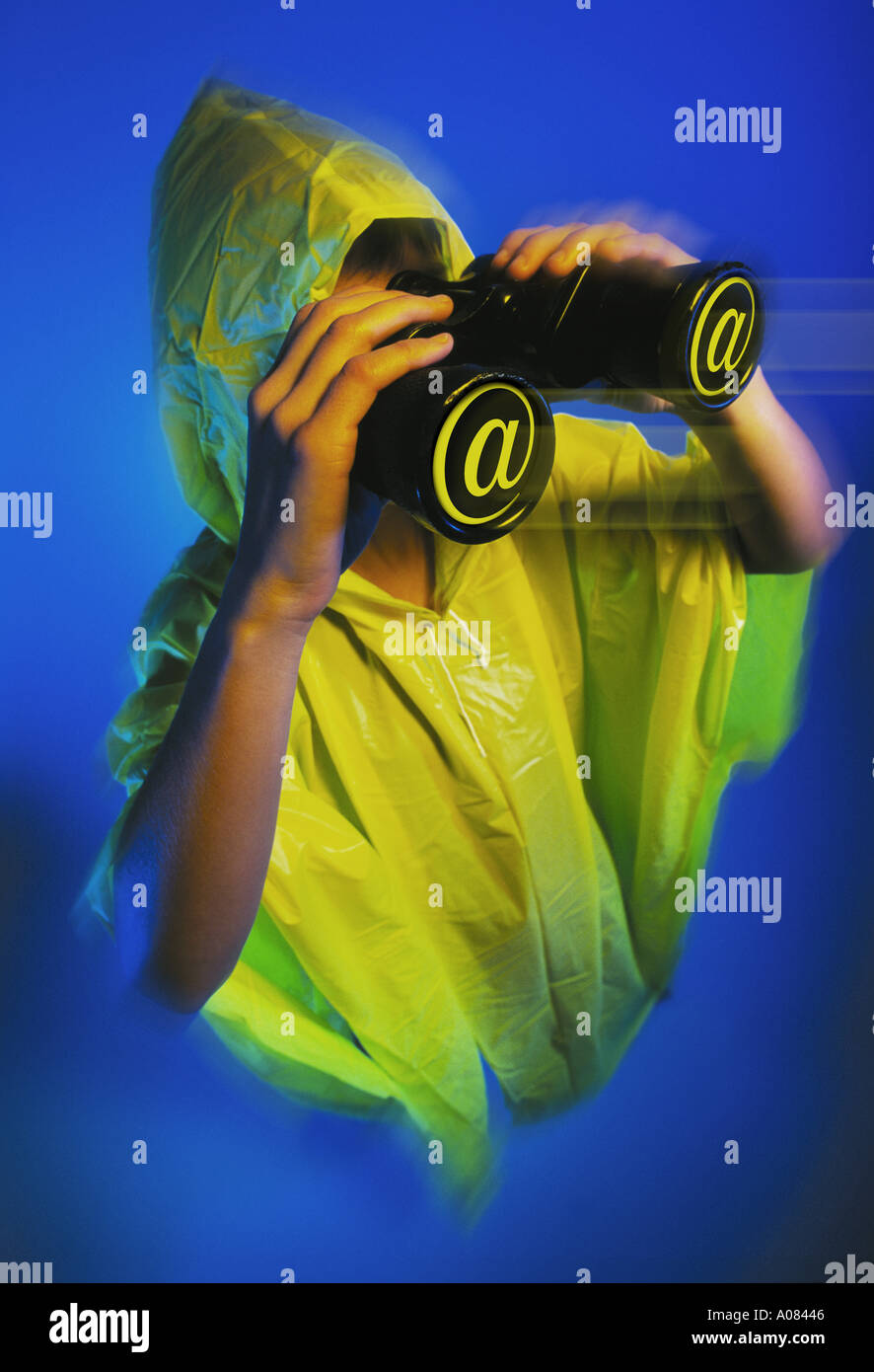 WOMAN WITH YELLOW RAINCOAT WATCHING WITH AT BINOCULARS Stock Photo