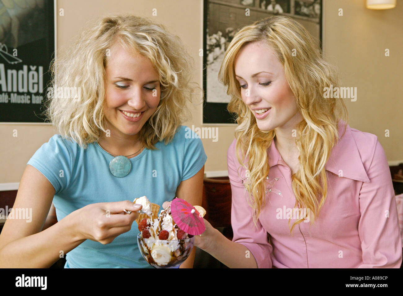 Zwei junge Frauen beim Eisessen in einem Cafe, two young women eating icecream at a cafe Stock Photo