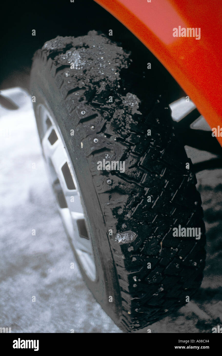 Studded car tyre in snow on red vehicle Norway JMH0912 Stock Photo
