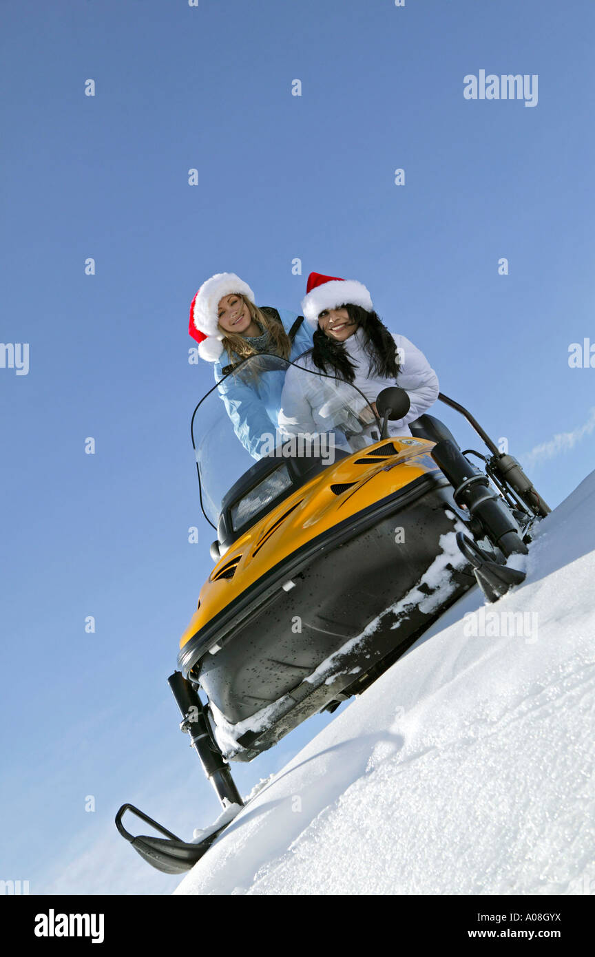 Zwei Frauen unterwegs mit einem Snowmobil, two women on snowmobile, skiscooter Stock Photo