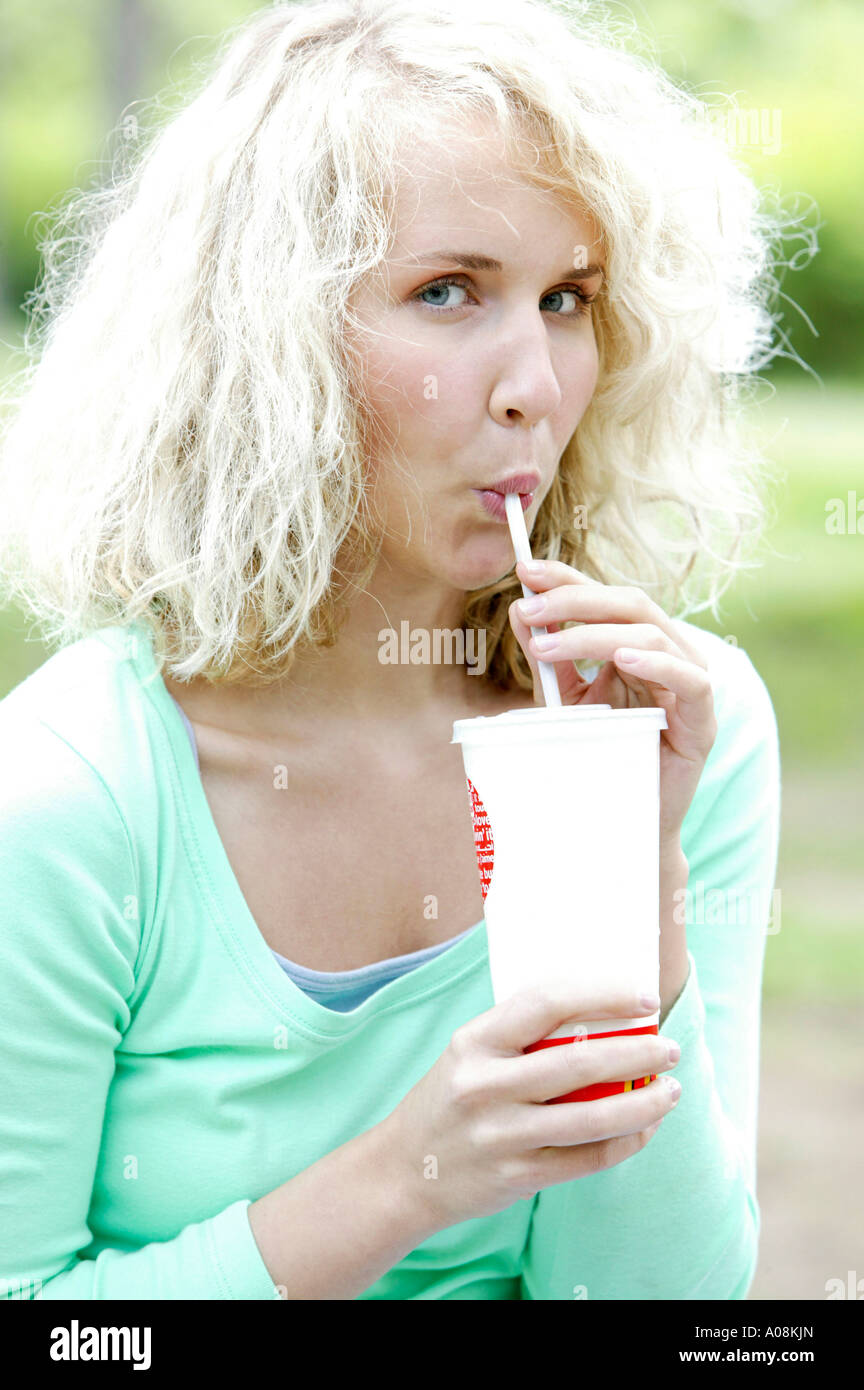 Junge Frau trinkt Coke mit einem Strohhalm, Woman drinking coke by quill  Stock Photo - Alamy