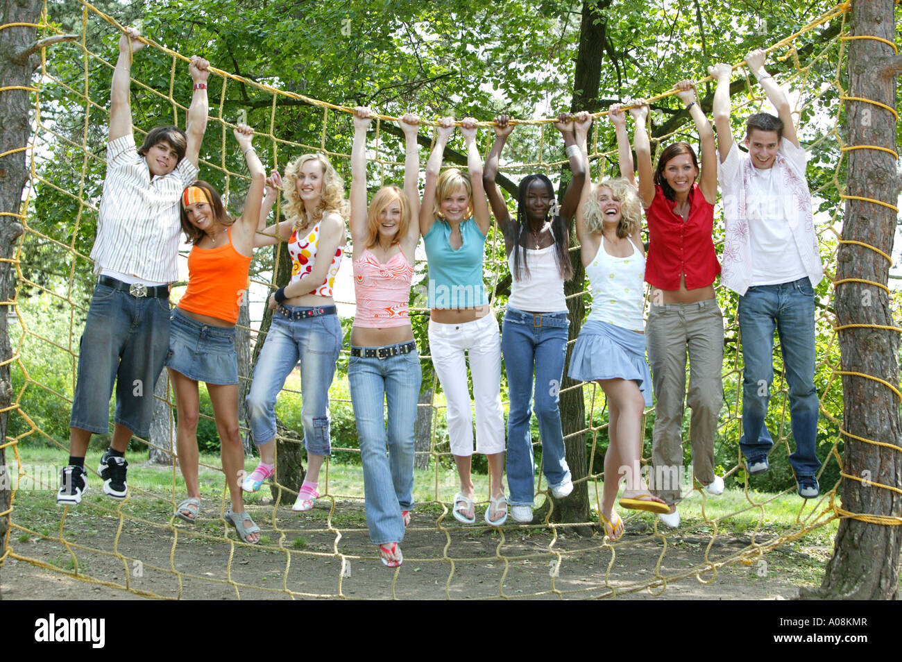 Eine Gruppe Studenten haengen auf einem Kletternetz, group of students hanging on climbing net Stock Photo
