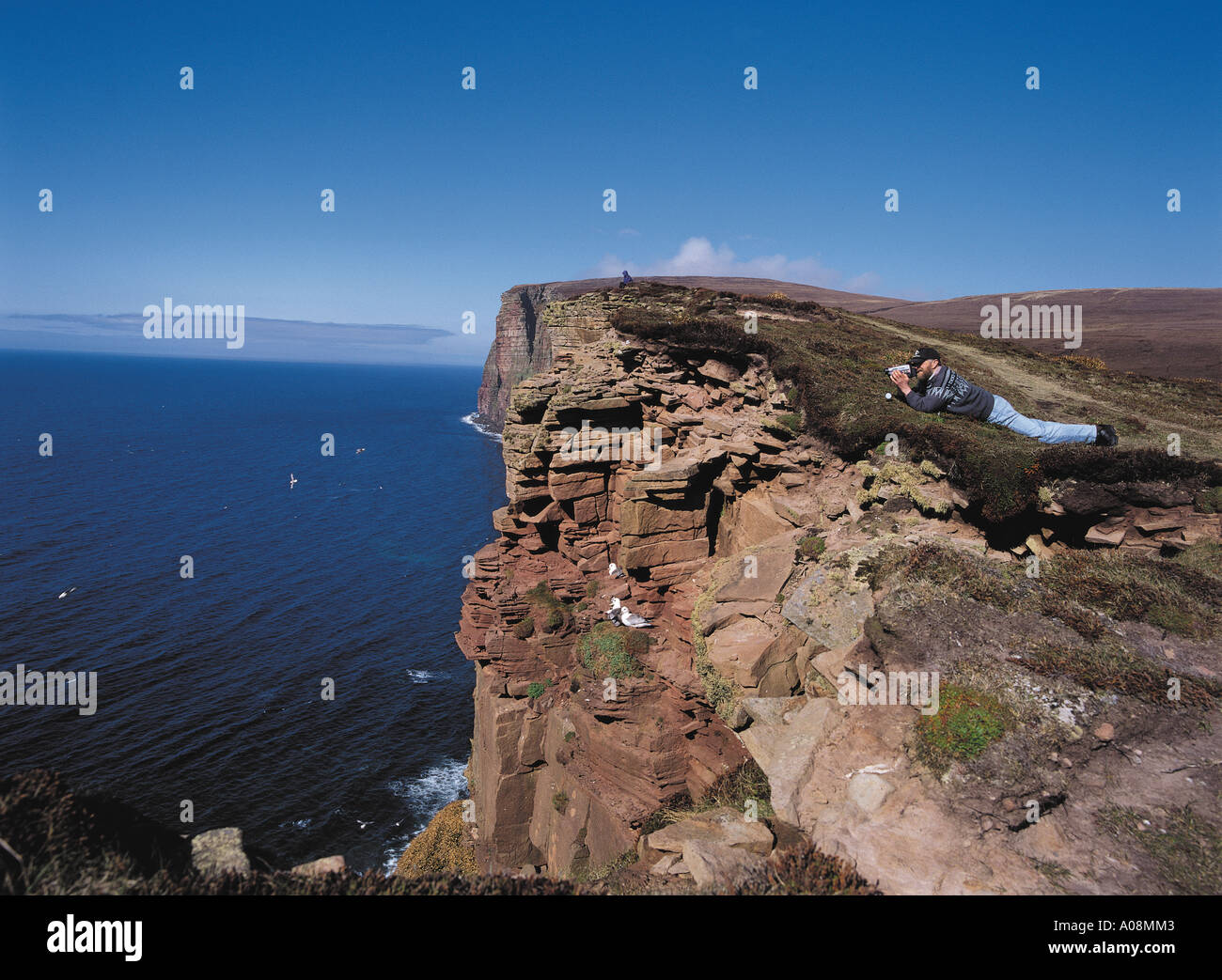 dh St Johns Head HOY ISLAND ORKNEY Tourist videoing sea birds cliffs binoculars cliff man bird watcher edge people scotland Stock Photo