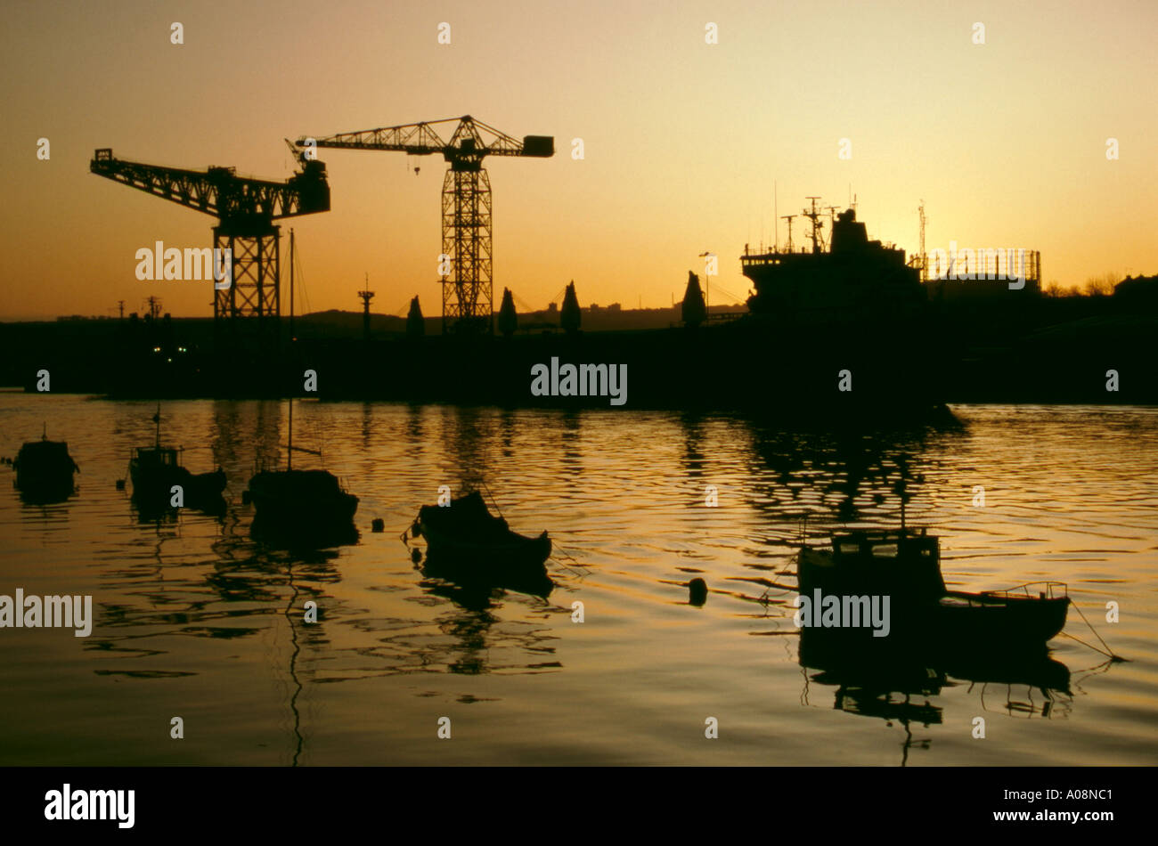 Moored pleasure craft and cranes seen over River Tyne at sunset, Newcastle upon Tyne, Tyne & Wear, England, UK. Stock Photo