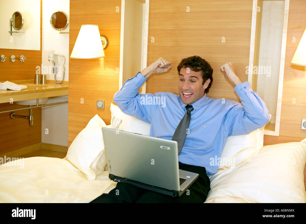 Manager arbeitet mit dem Laptop in seinem Hotelzimmer, Happy Manager working on a laptop in his hotel room Stock Photo