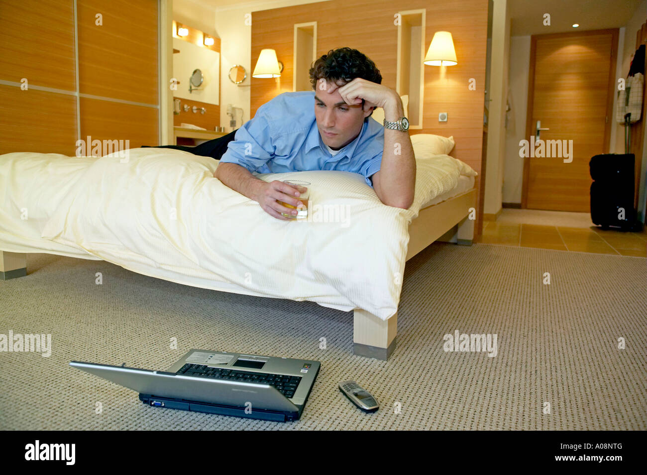 Manager arbeitet mit dem Laptop in seinem Hotelzimmer, Manager working on a laptop in his hotel room Stock Photo