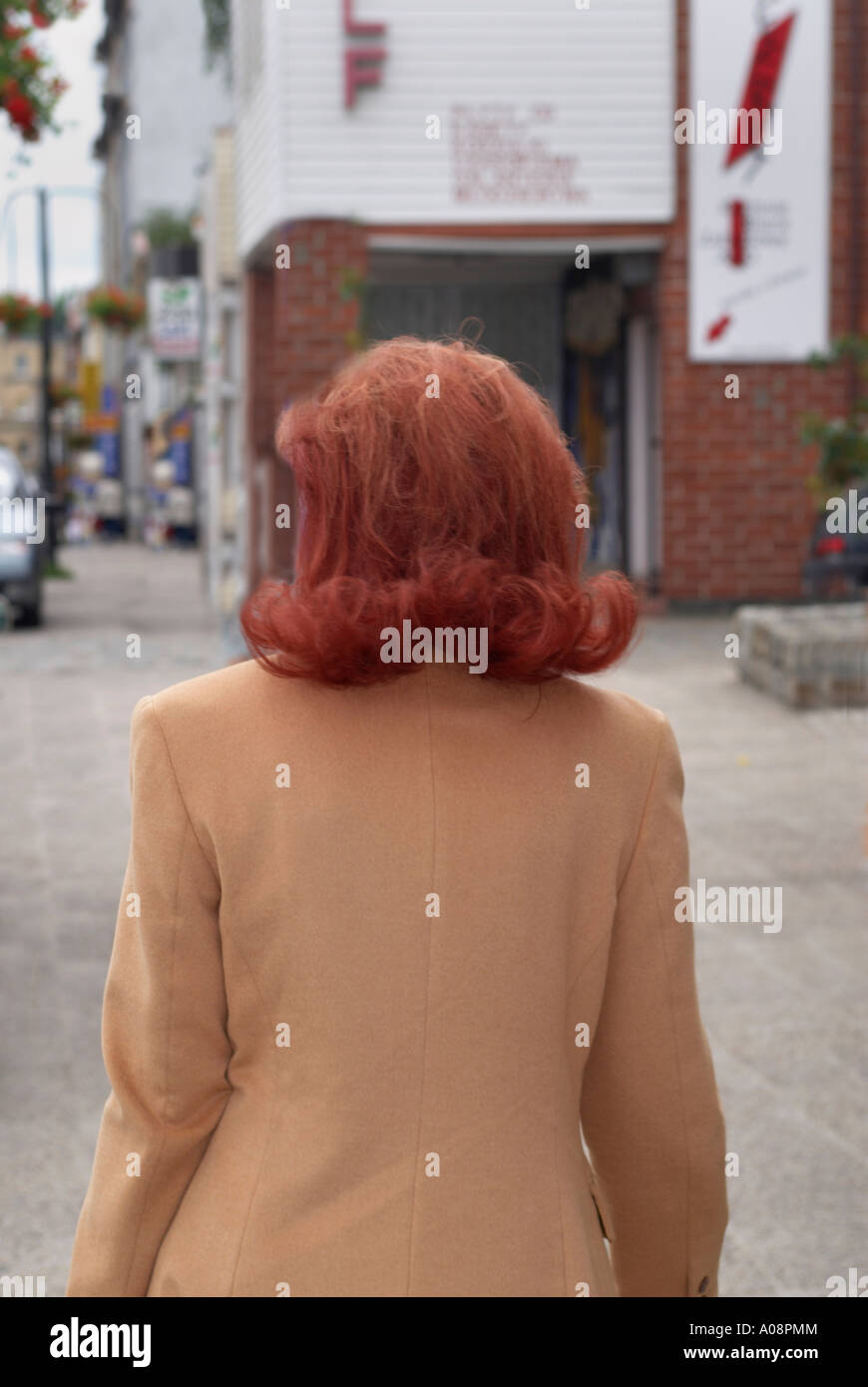Woman walking down a street with red hair in flick ups Stock Photo - Alamy