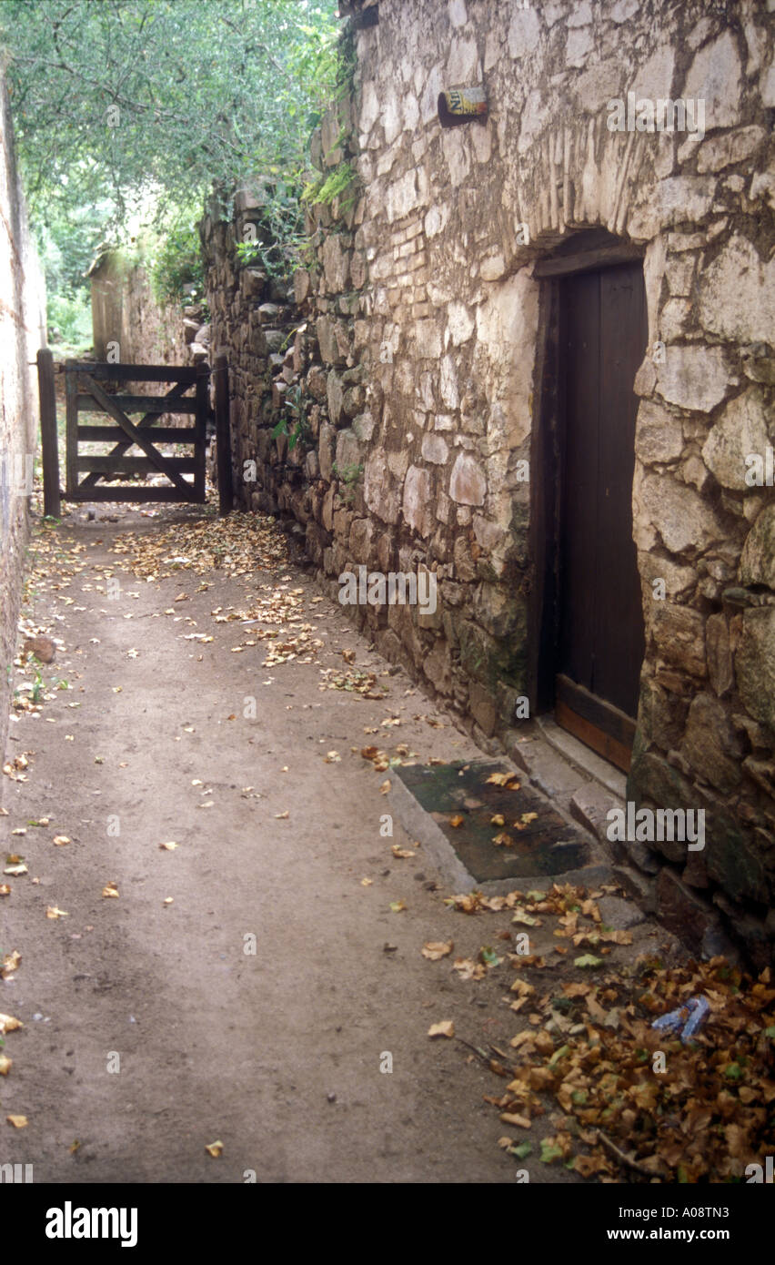 Quite and antique path next to a stony wall in Cordoba, Argentina Stock Photo