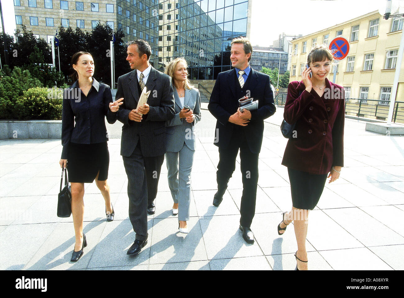 Group of business executives walking together outdoors Stock Photo - Alamy