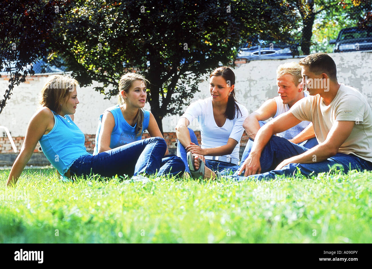 A group of young people sitting on a lawn Stock Photo - Alamy