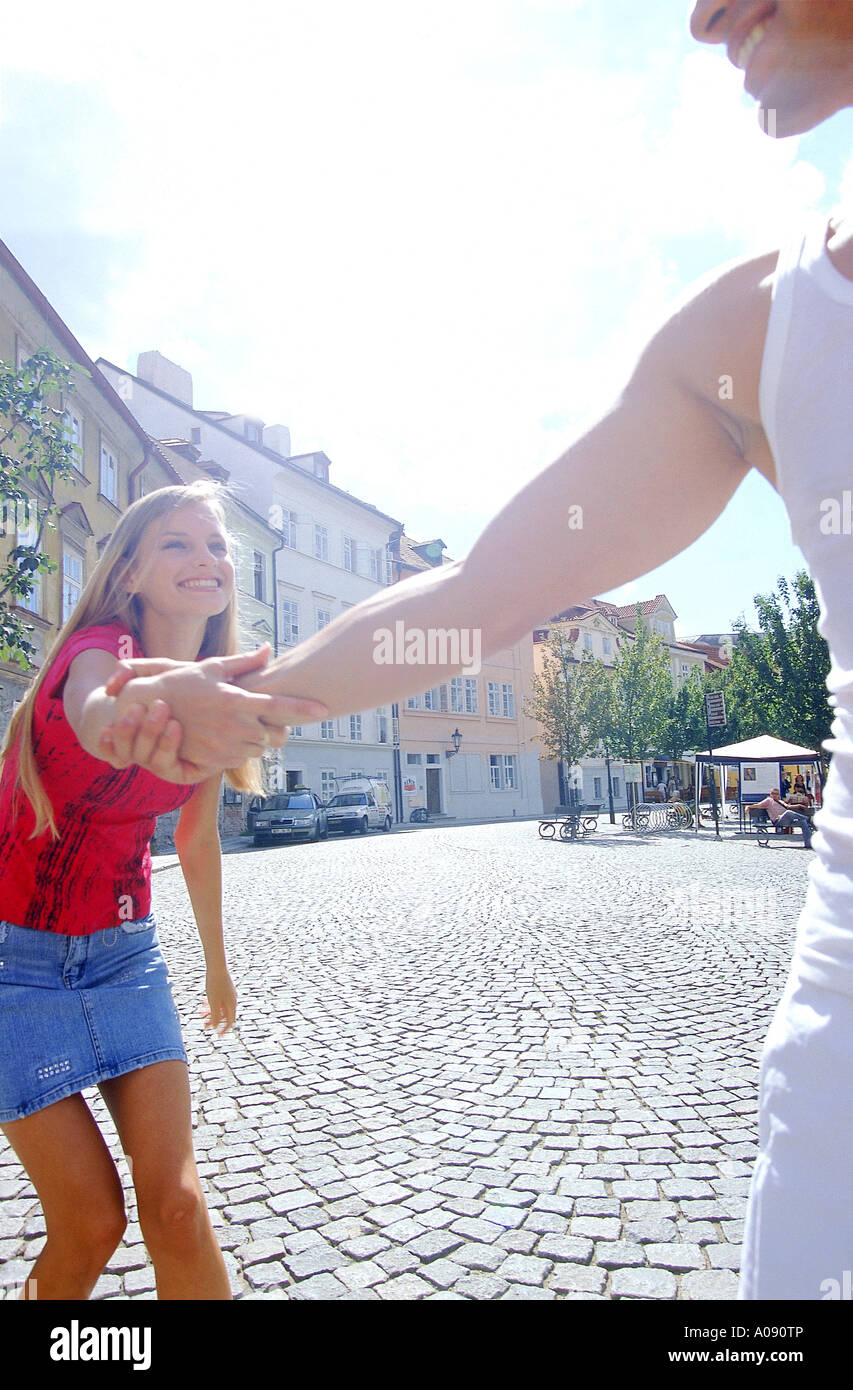 Young man pulling young woman by her arm Stock Photo