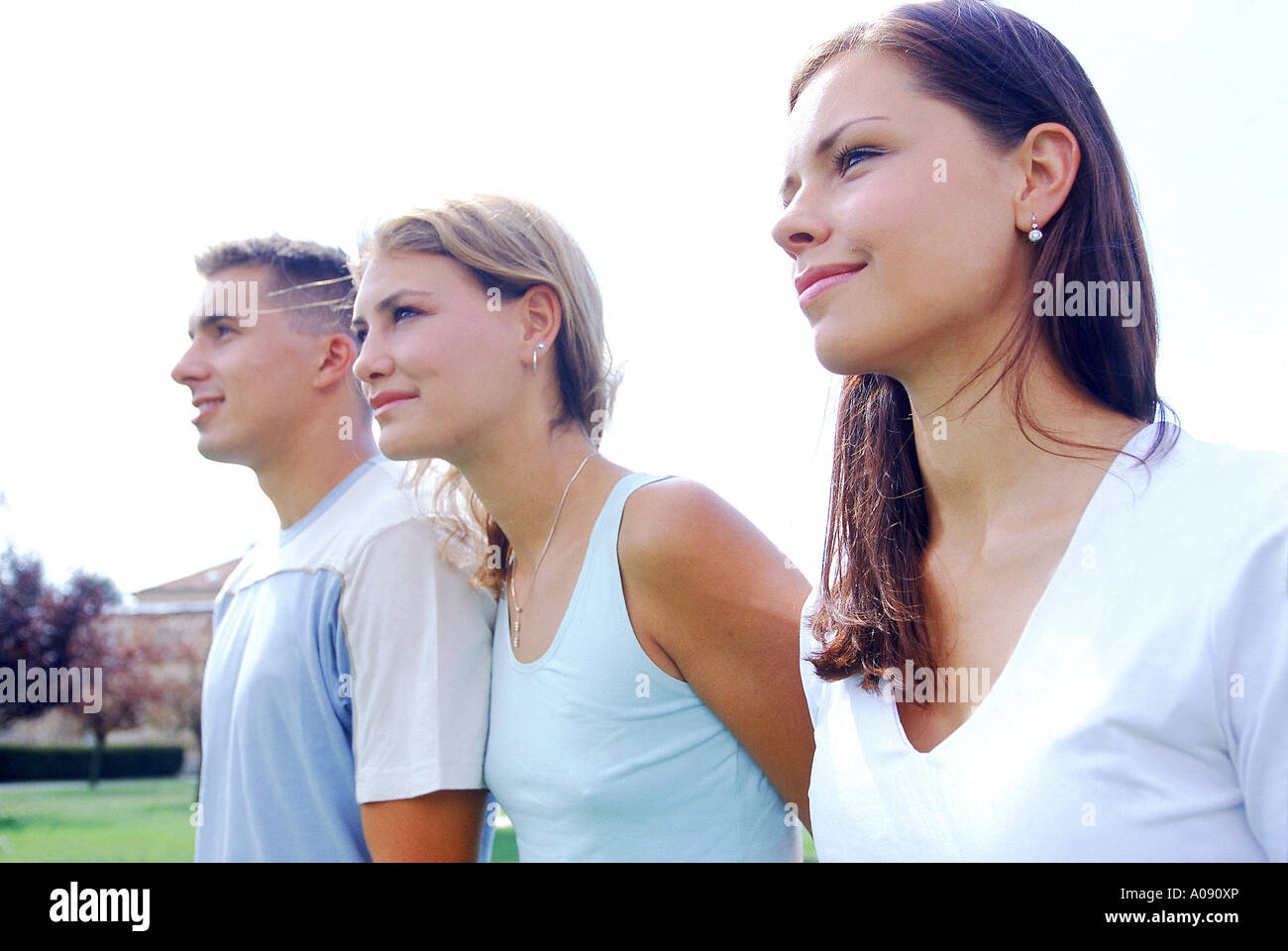 A young man standing with two young women Stock Photo - Alamy