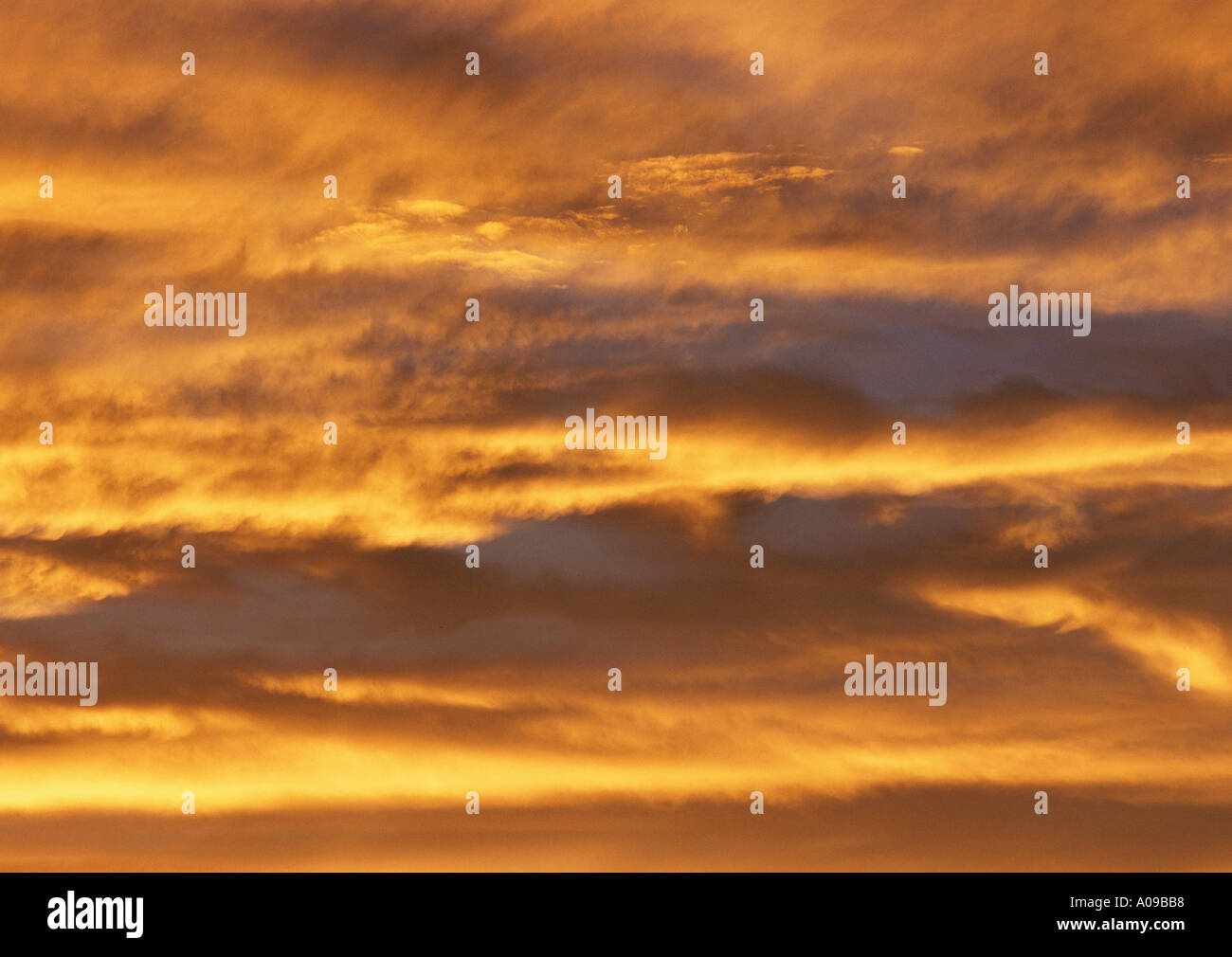A dramatic skyscape at sunset with an orange and golden fiery glow on ...