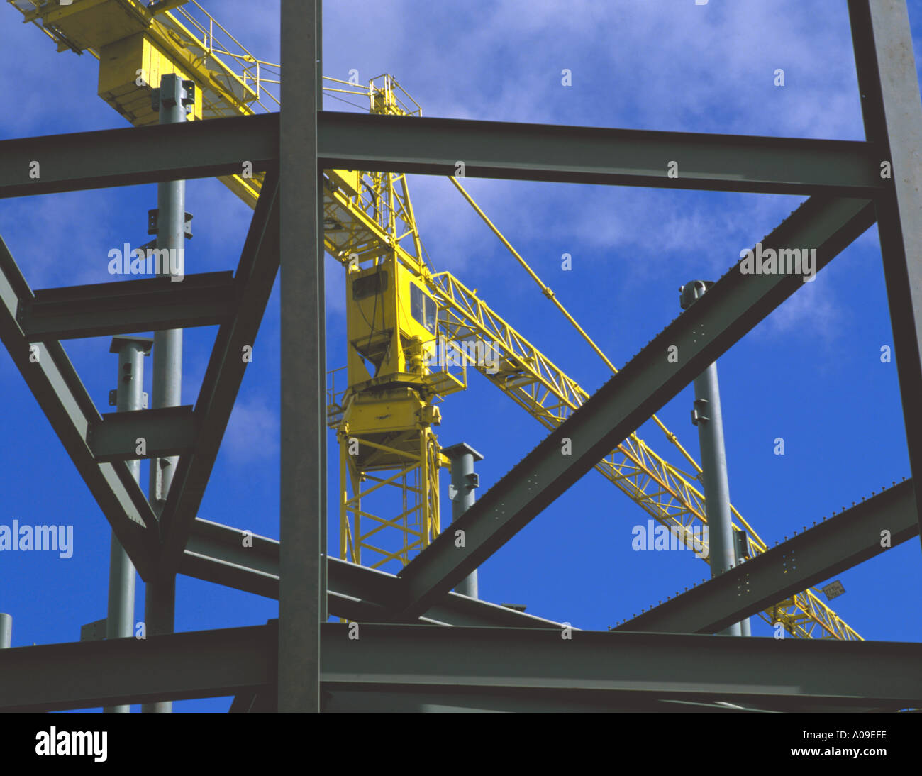 Tower crane seen through steel frame of a building, UK. Stock Photo
