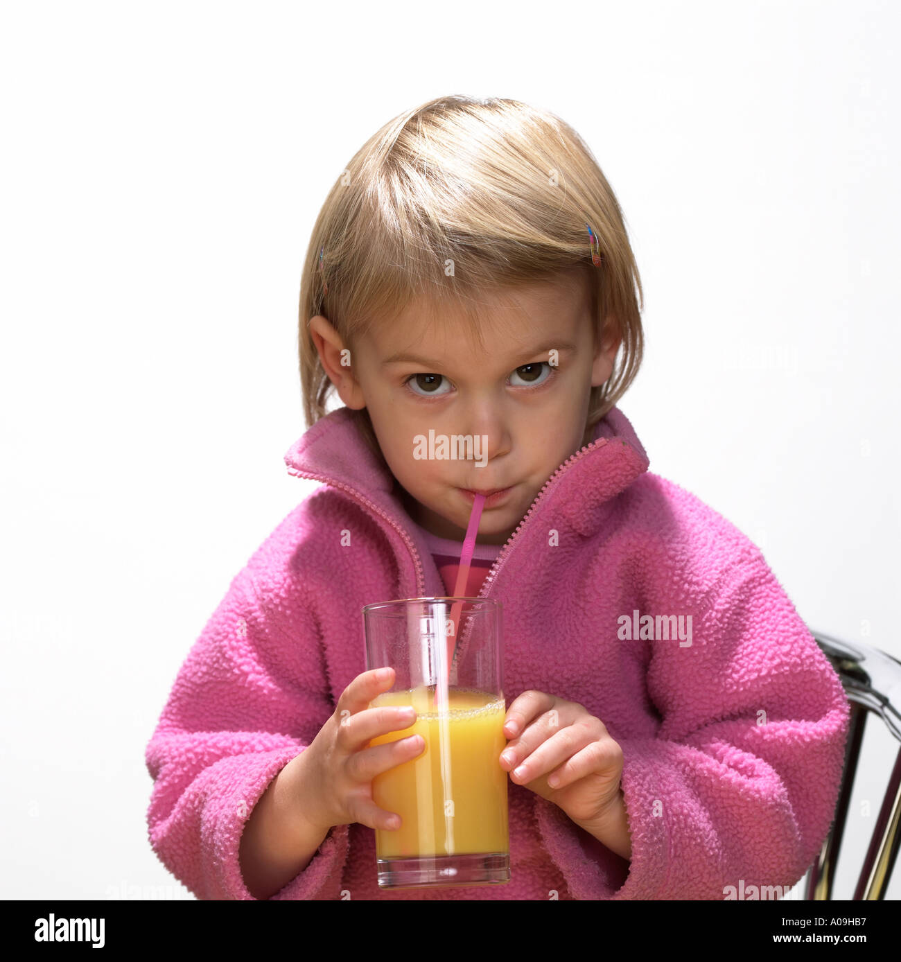 Little girl drinking orange juice with straw Keywords people juice healthy child kids Stock