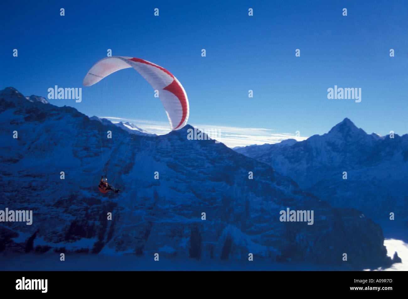 Parasailer gliding above Hasli Valley in front of Bernese Alps Switzerland winter Stock Photo
