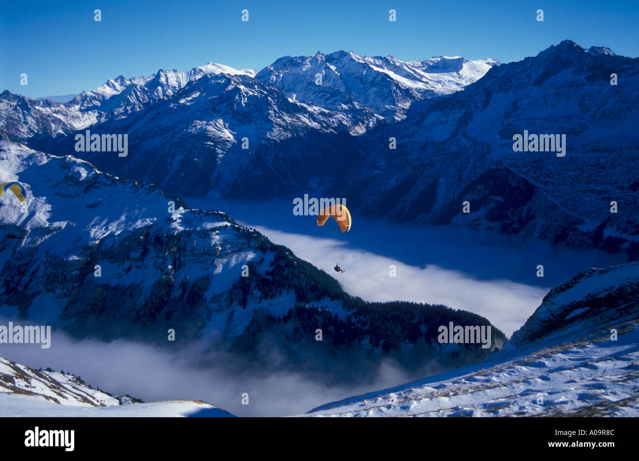 Parasailing above Haslital or Halsi Valley with bernese Alps winter Switzerland Stock Photo