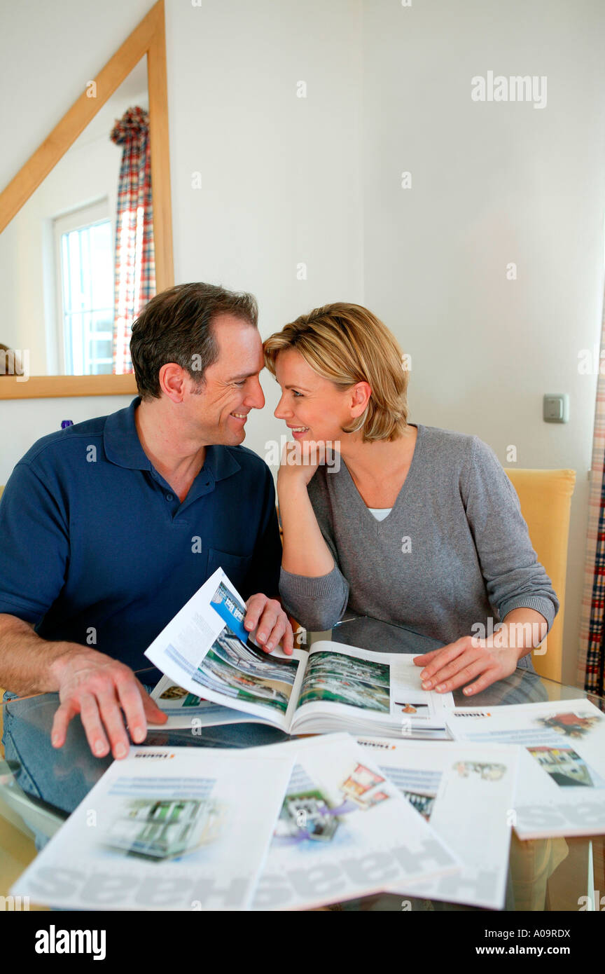 Paar blaettert in einem Katalog fuer Haeuser, couple catalogue shopping Stock Photo