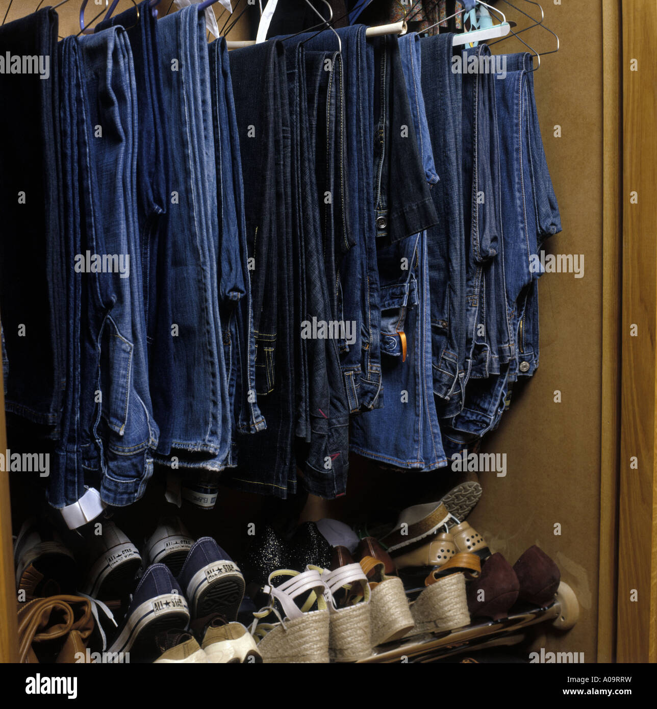 a selection of jeans and shoes in a wardrobe Stock Photo