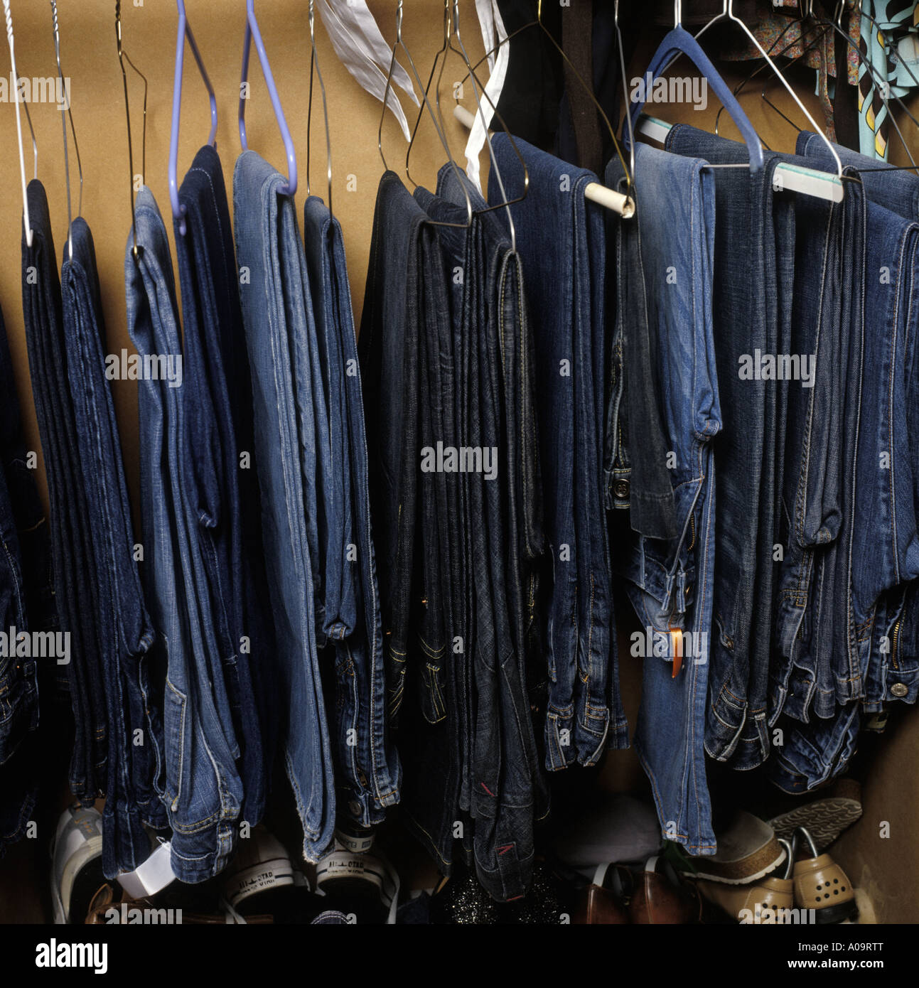 a selection of jeans hanging up in a wardrobe Stock Photo