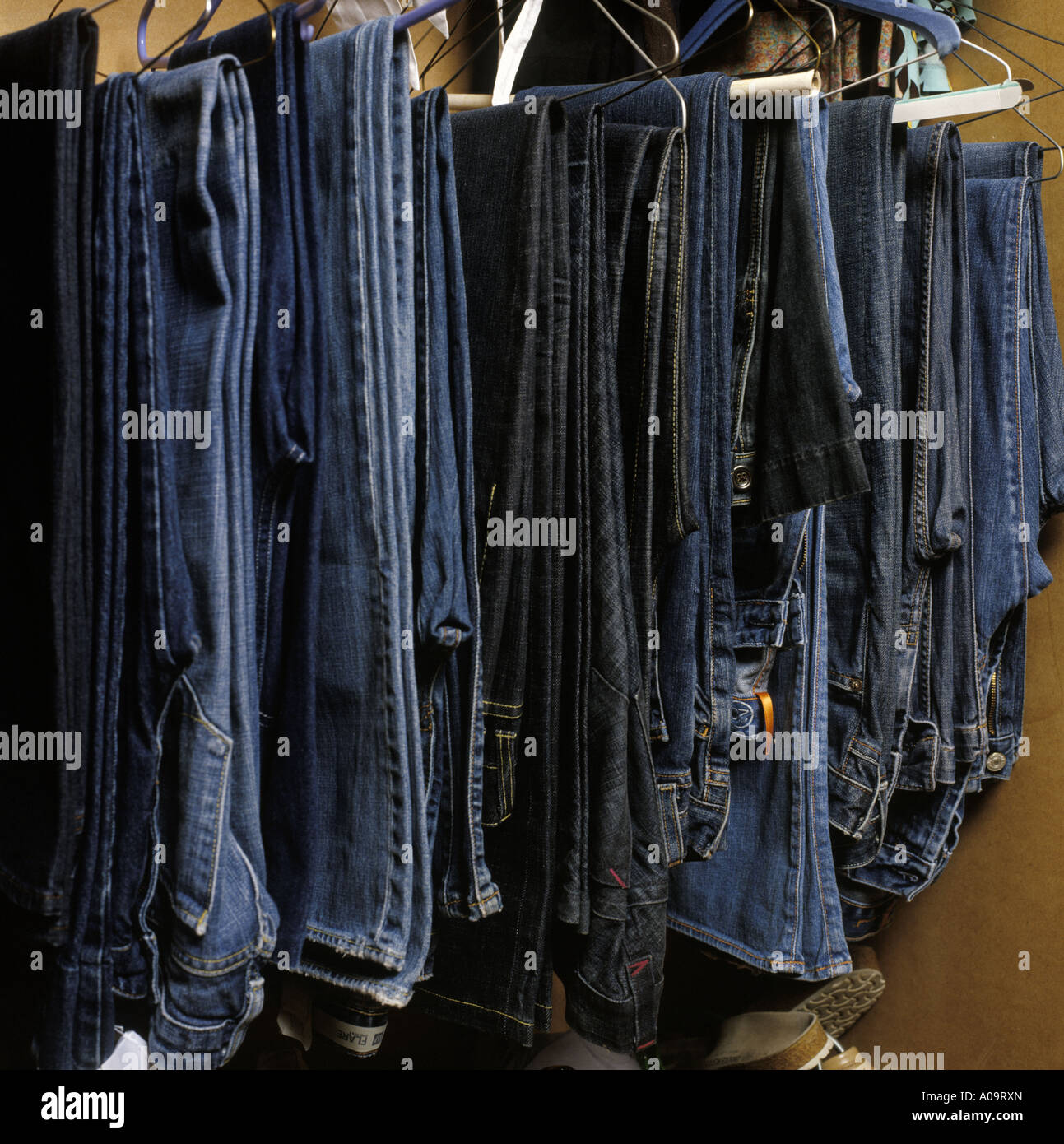 a selection of jeans hanging in a wardrobe Stock Photo