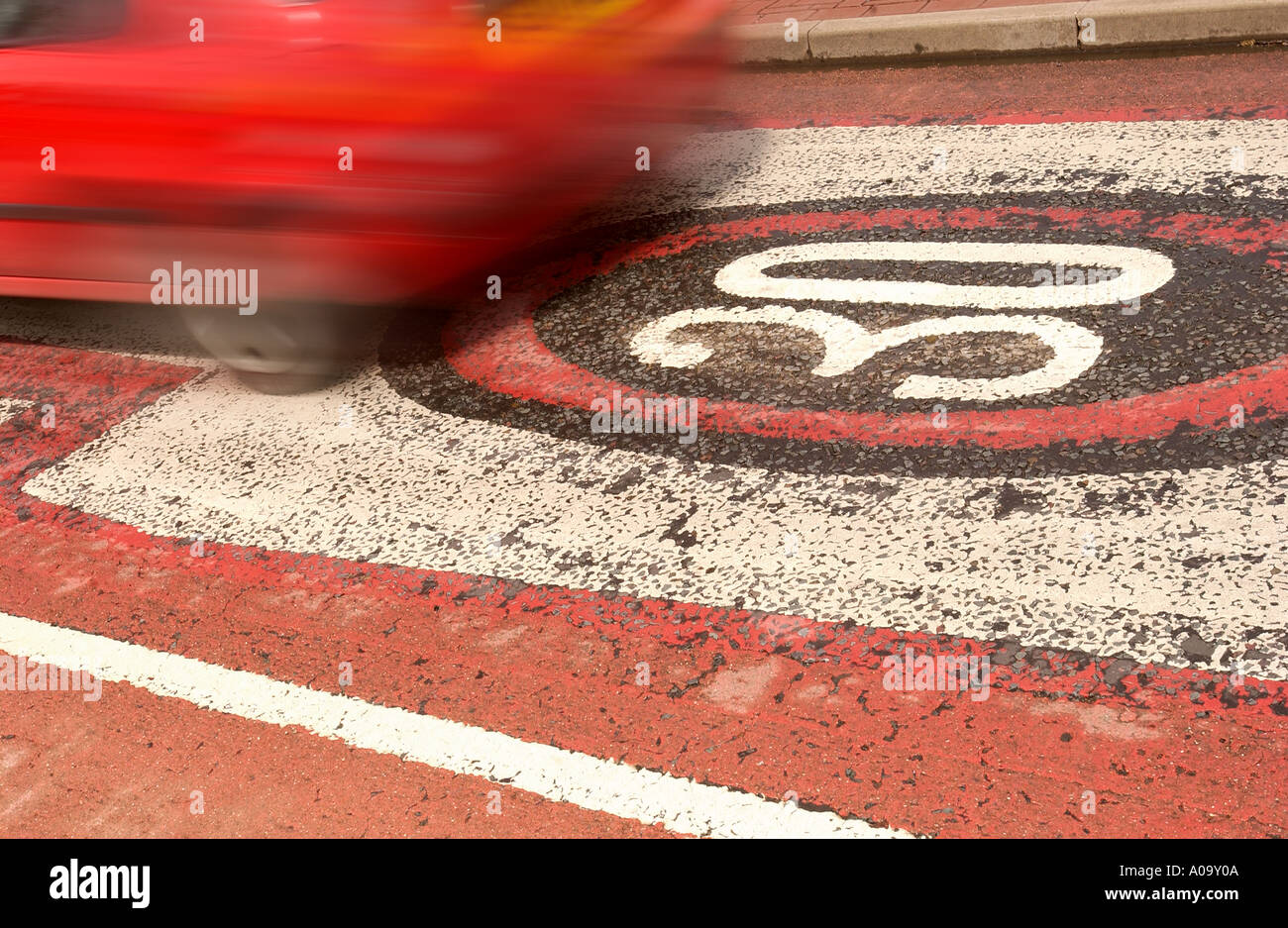 A CAR PASSES OVER A WORN THIRTY MILES PER HOUR SPEED WARNINGS PAINTED ONTO THE ROAD UK Stock Photo