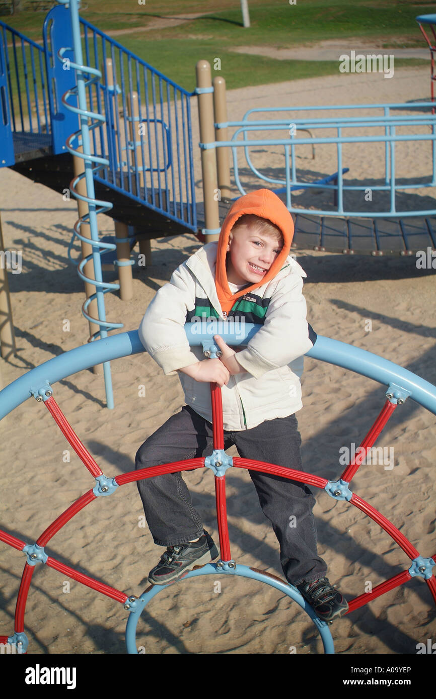 Child playing on public playground monkey bars smiling Stock Photo