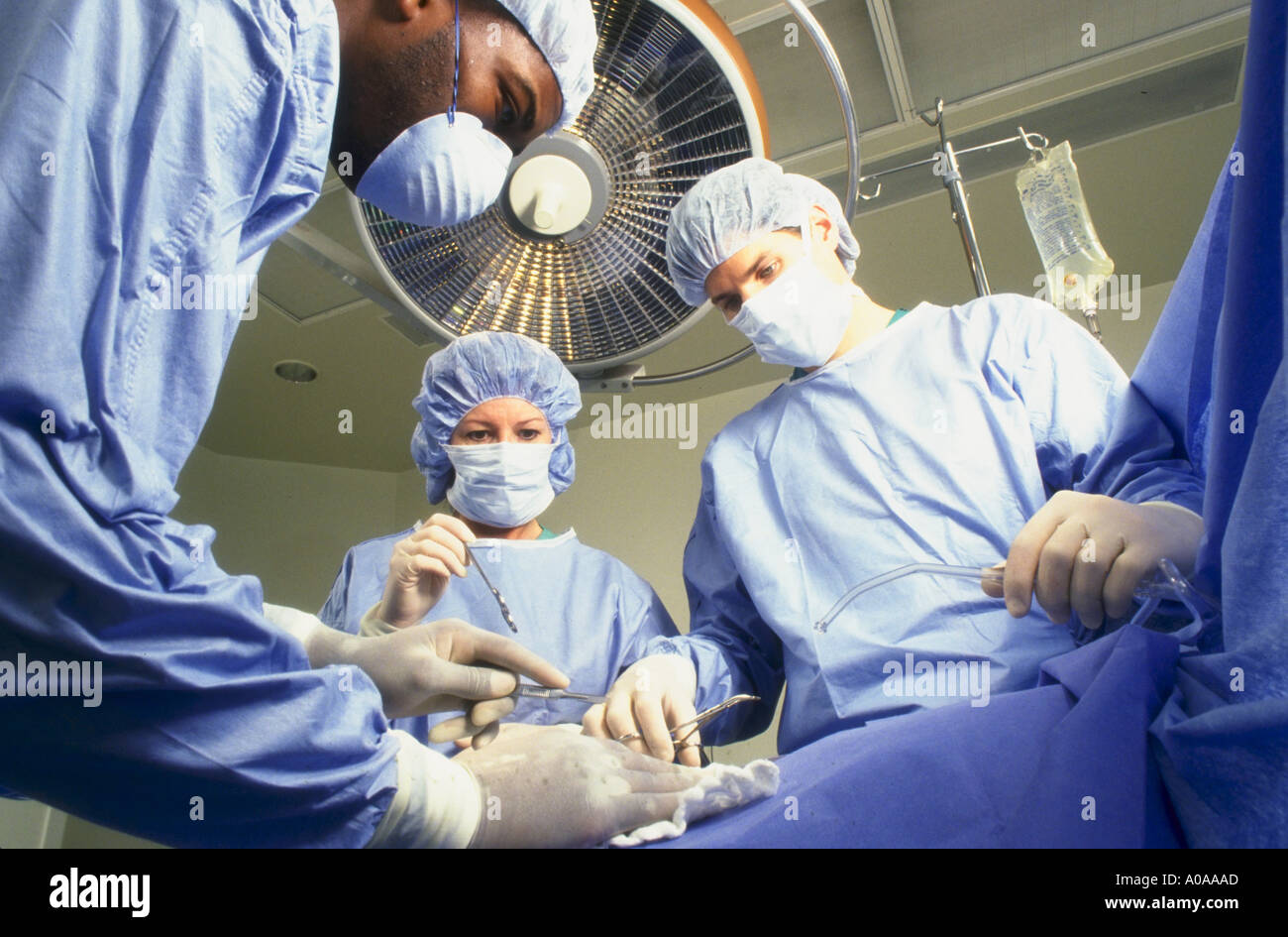 Doctors and nurse in operating room performing abdominal surgery Stock Photo