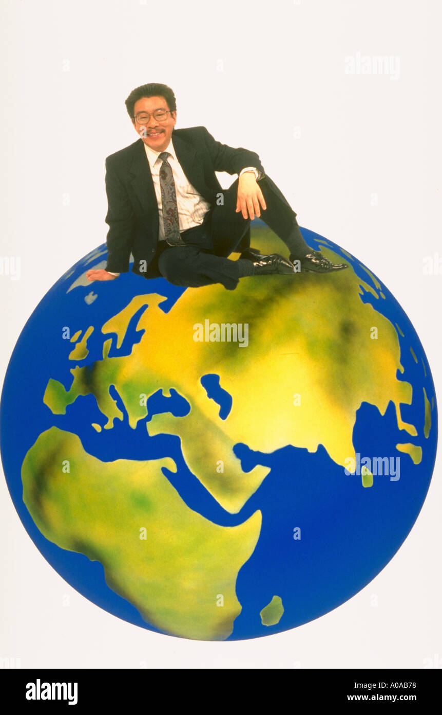 Asian businessman siting on top of the world Stock Photo