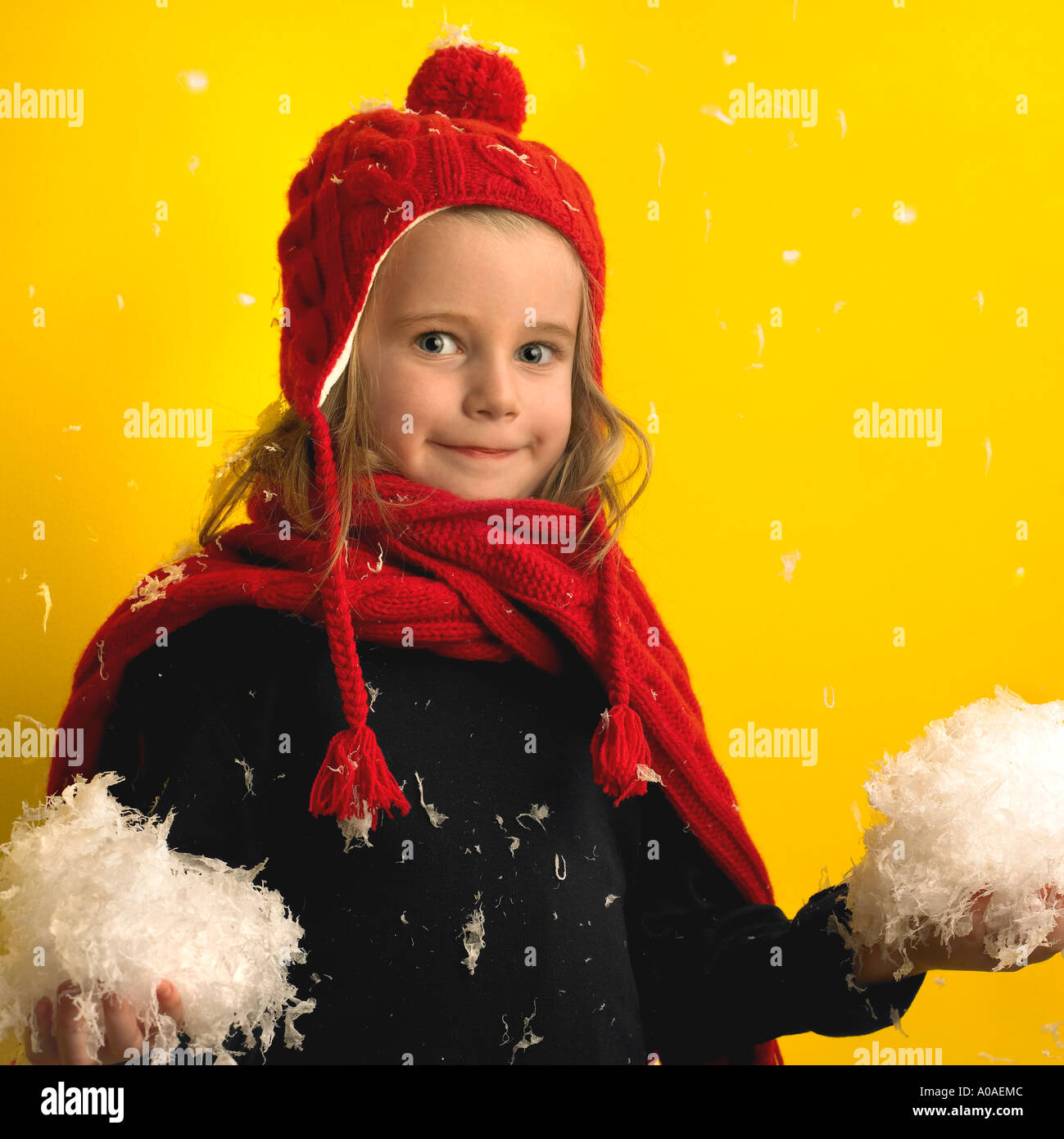 A mischievious little girl poses with a couple of snow balls ready to throw! Stock Photo