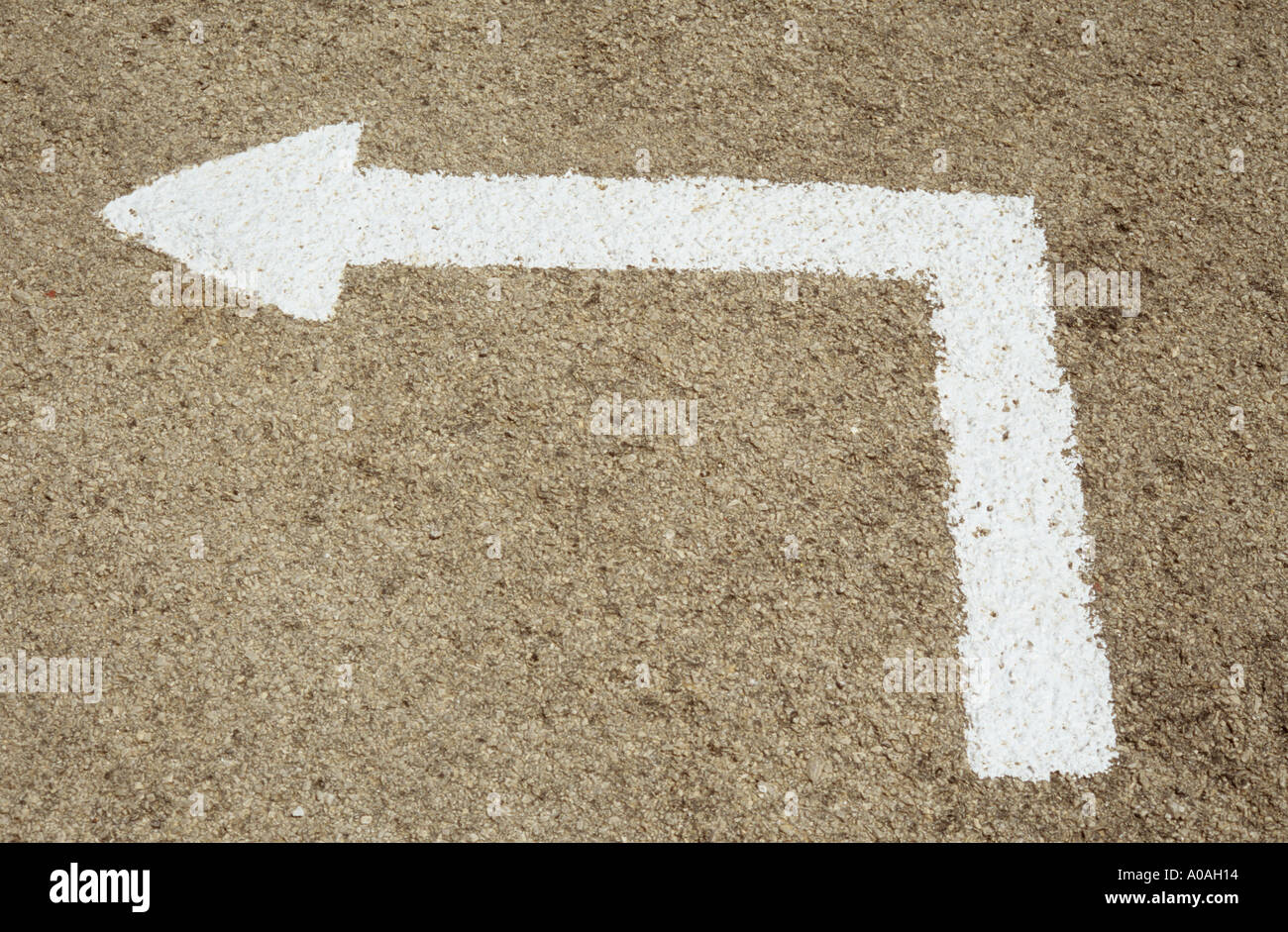 White painted right angled arrow pointing to left on road Stock Photo