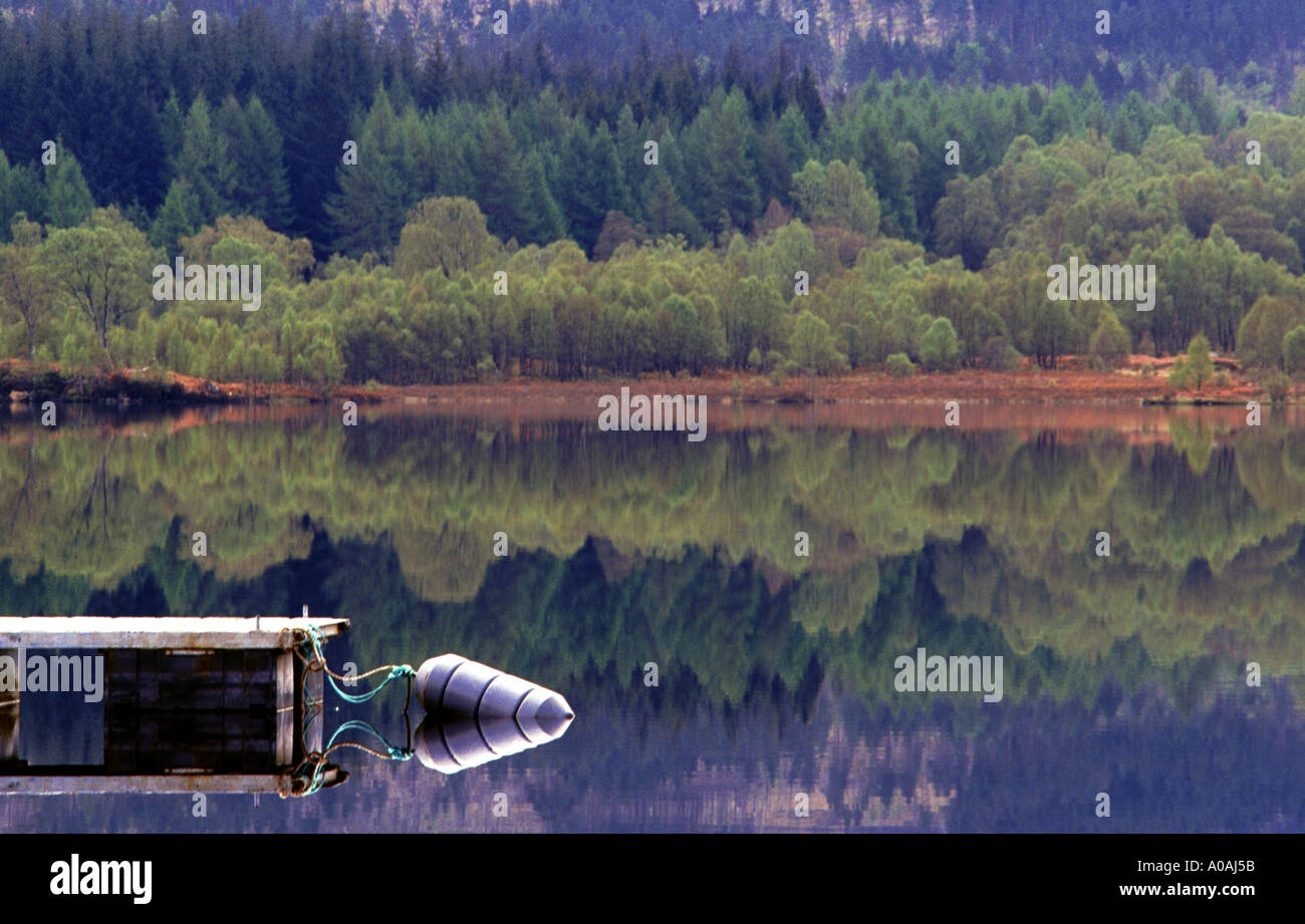 Pontoon and buoy reflected in still waters of Loch Garry Scottish Highlands Stock Photo