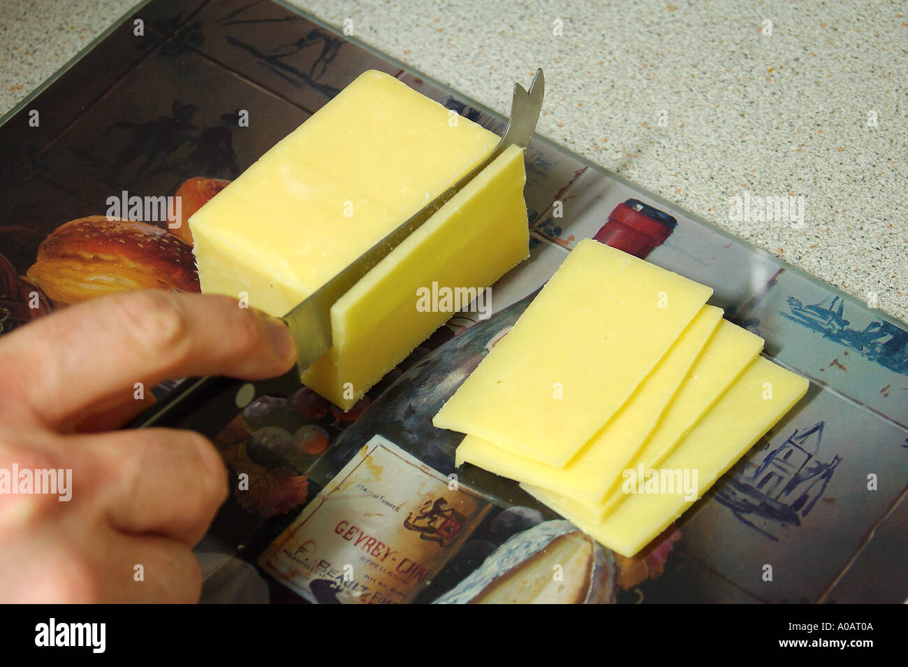 Cutting a block of tasty cheese with a cheese knife, Australia Stock