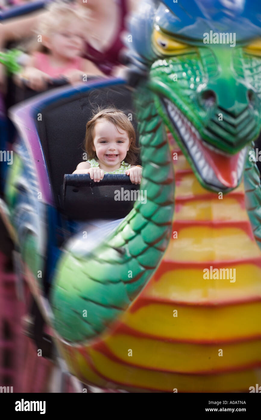 Little Caucasian girl riding kiddy roller coaster Stock Photo Alamy
