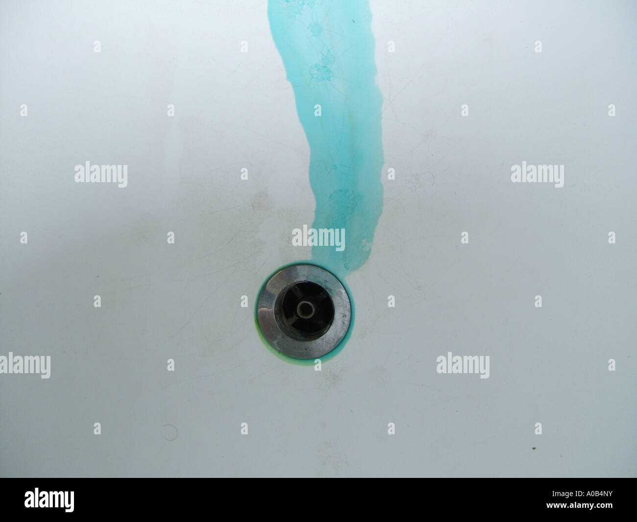 blue green liquid spillage going down plug hole Stock Photo - Alamy