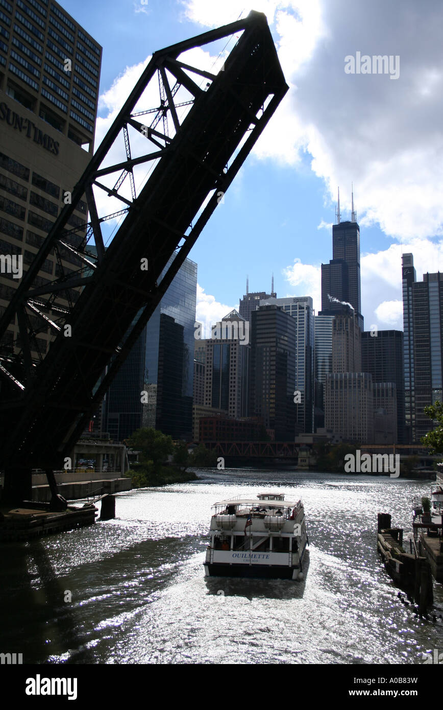 sightseeing boat passing under raised bridge along Chicago river ...
