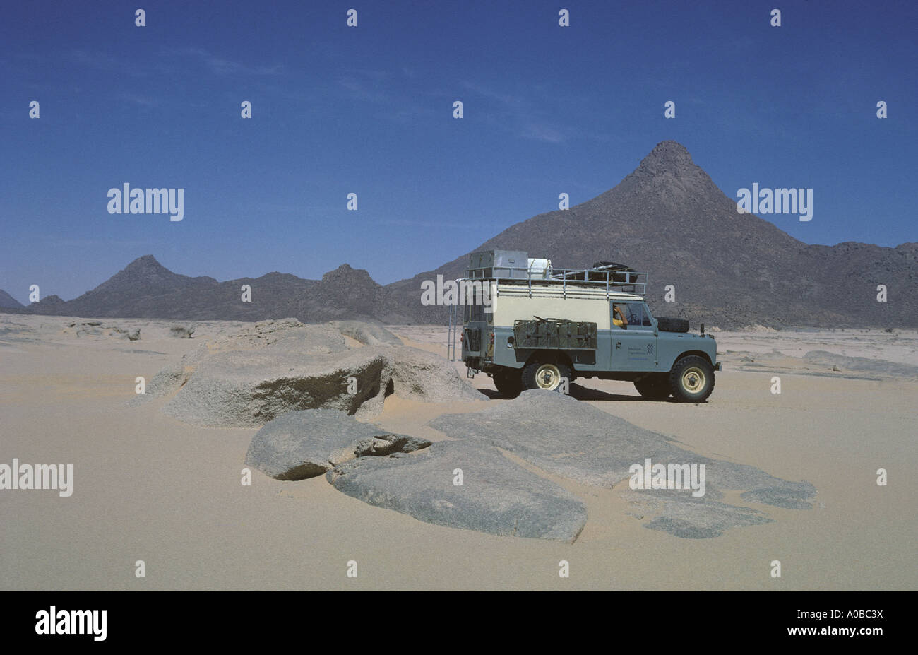 0254 07 A Series IIA one ton model Land Rover in front of Mount Tiska the main navigation marker in this part of the Sahara Dese Stock Photo