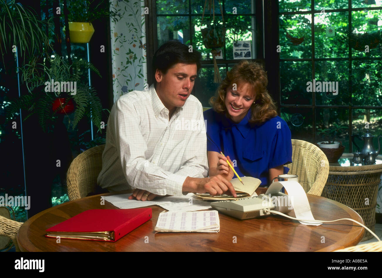 Yuppie couple works on budget in kitchen sunroom in Maryland Stock Photo