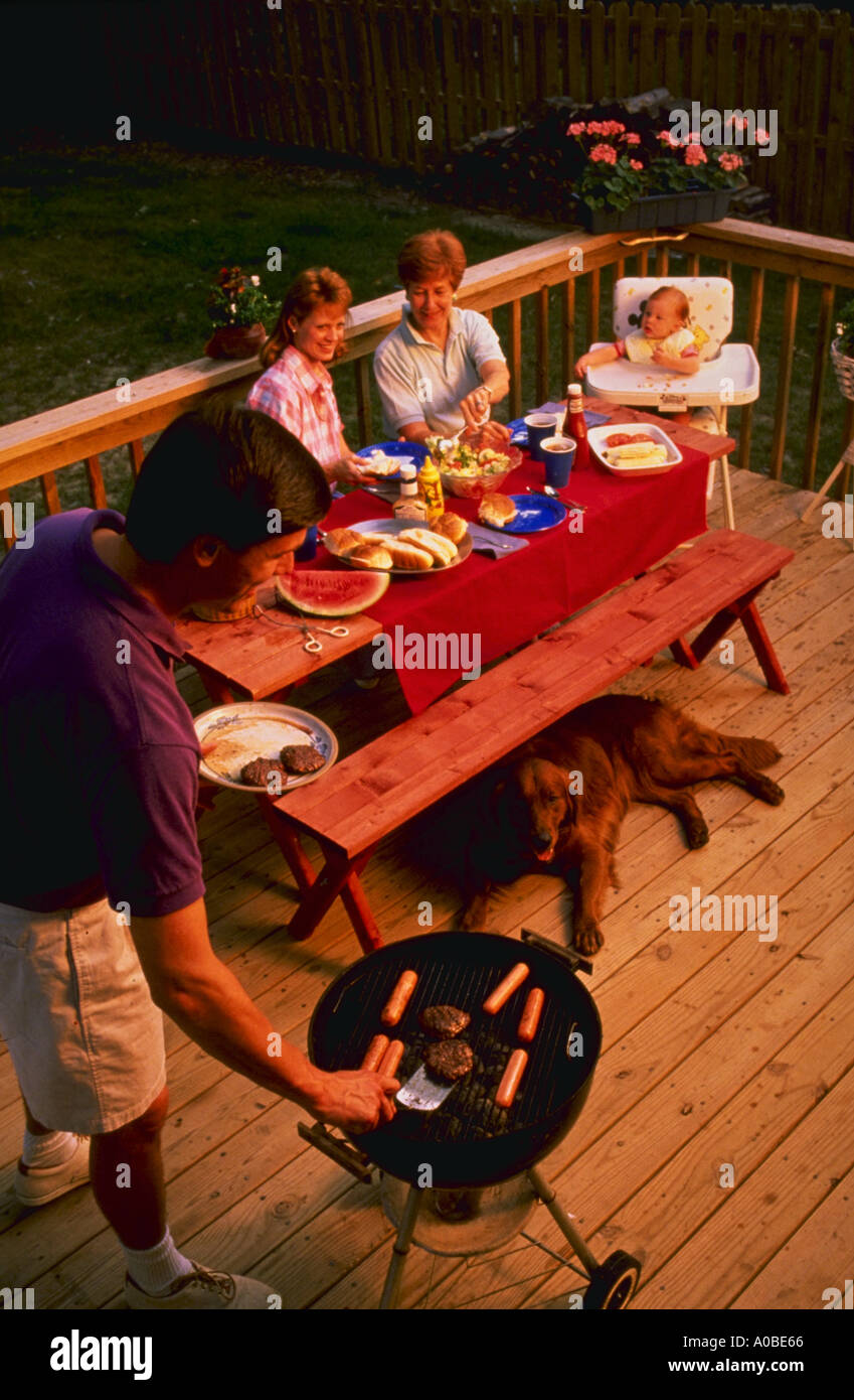 Three generations of family having cook out on back porch Stock Photo